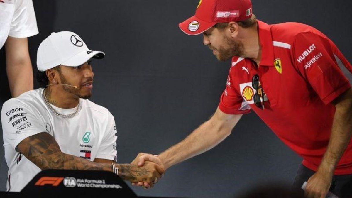 Sebatian Vettel (Ferrari), a la derecha, saluda a Lewis Hamilton (Mercedes), en el inicio de la conferencia de prensa de presentación del GP de Australia.-AFP / WILLIAM WEST