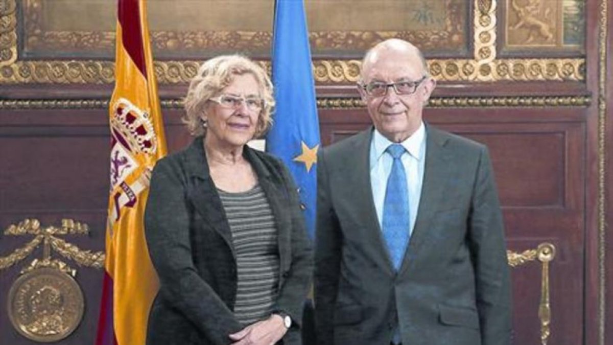 La alcaldesa de Madrid, Manuela Carmena, y el ministro de Hacienda, Cristóbal Montoro, en una reunión el pasado año.-/ EFE / KIKO HUESCA
