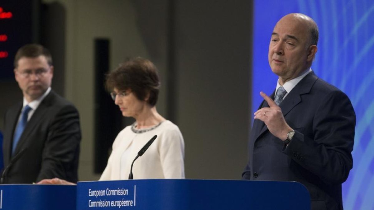 El vicepresidente del Ejecutivo comunitario para el Euro, Valdis Dombrovskis (i), la comisaria europea de Empleo, Marianne Thyssen (c), y el comisario europeo de Asuntos Económicos de la Unión Europea (UE), Pierre Moscovici (d), durante la rueda de prensa-OLIVIER HOSLET / EFE