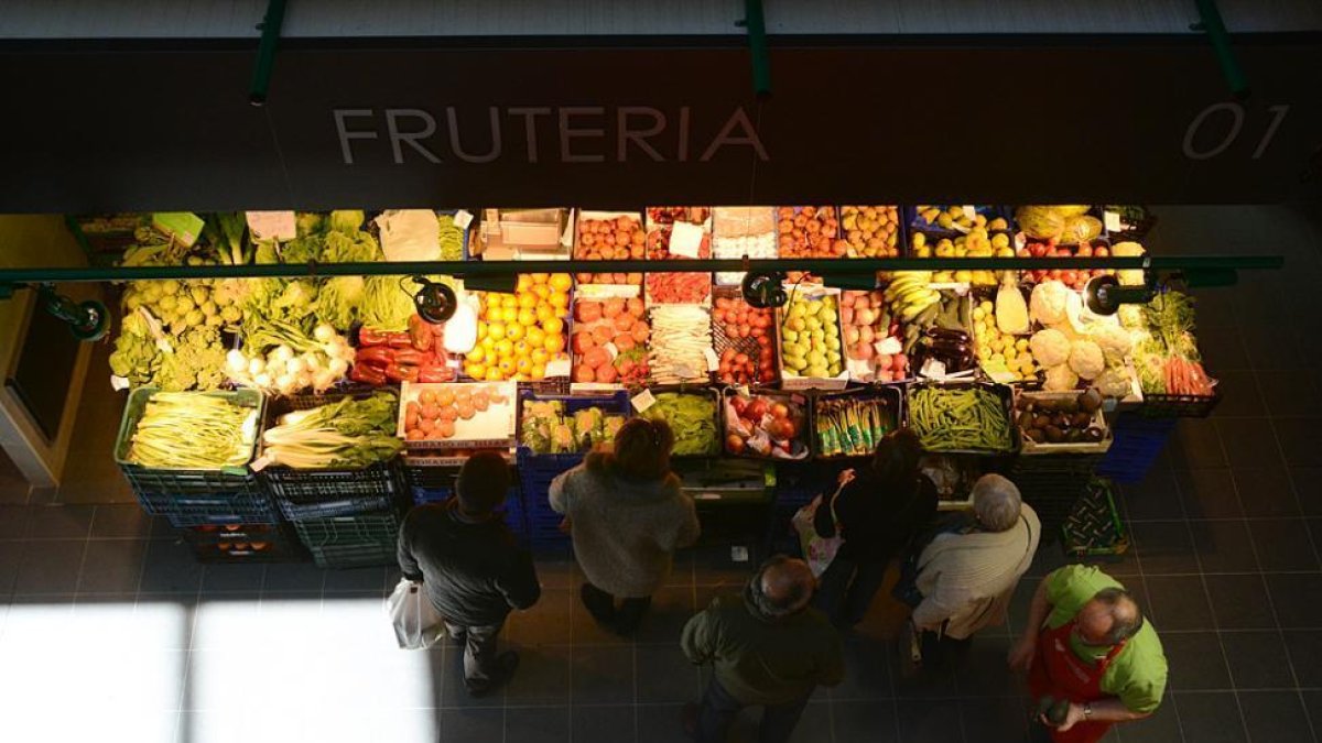 Varias personas esperan su turno ante el puesto de frutería.-ÁLVARO MARTÍNEZ