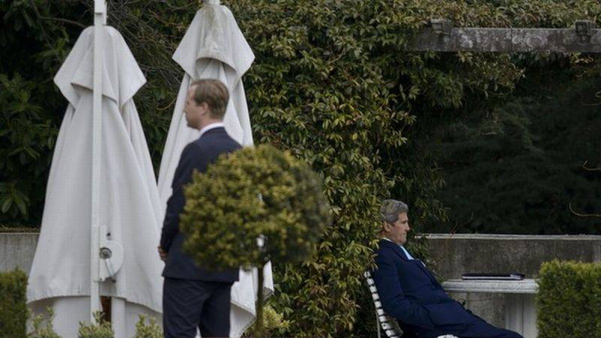 El secretario de Estado de EEUU, John Kerry (sentado), durante un receso en las negociaciones.-Foto: BRENDAN SMIALOWSKI / AFP