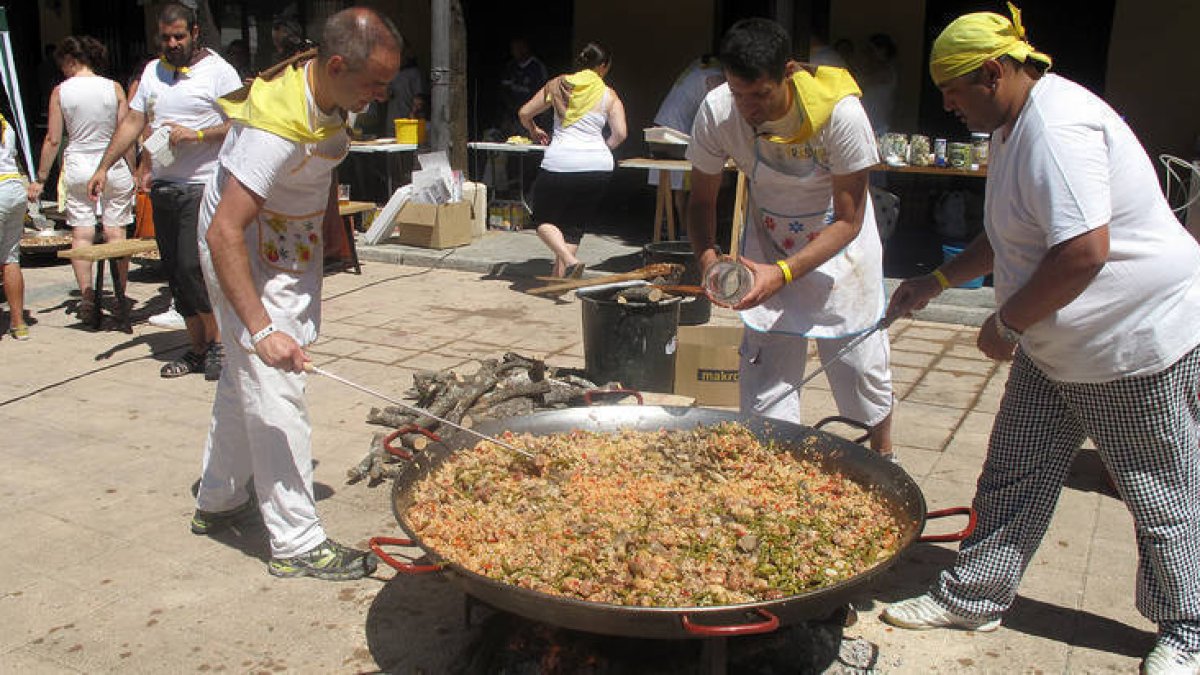 Los miembros de las Peñas preparando sus paellas ayer en la plaza del Rastro. / JAVIER NICOLAS -