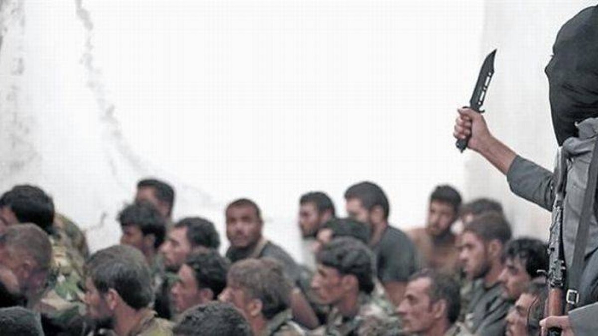 Combatiente del Estado Islámico junto a soldados sirios, tras la toma de una base cerca de Raqqa.-Foto: AP