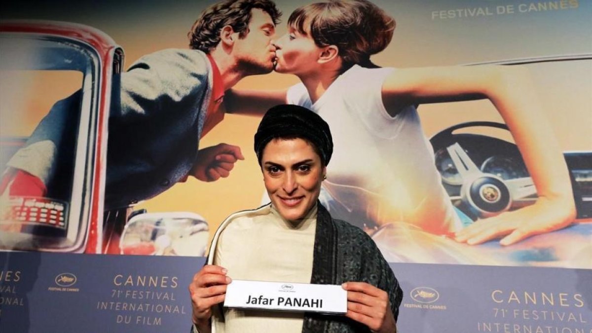 Behnaz Jafari, una de las protagonistas de 3 faces, muestra el cartel del director, Jafar Panahi, que no puede estar presente en Cannes al tener prohibida la salida de Irán.-ERIC GAILLARD (REUTERS)
