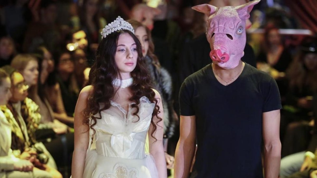 Sabrina Piper, esposada a un modelo con una careta de cerdo.-AP / BEBETO MATTHEWS