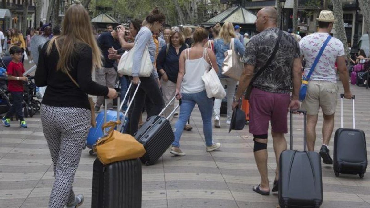 Turistas con maletas.-ALBERT BERTRAN