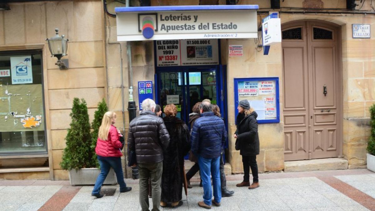 Varias personas hacen cola en el acceso a una administración.-ÁLVARO MARTÍNEZ