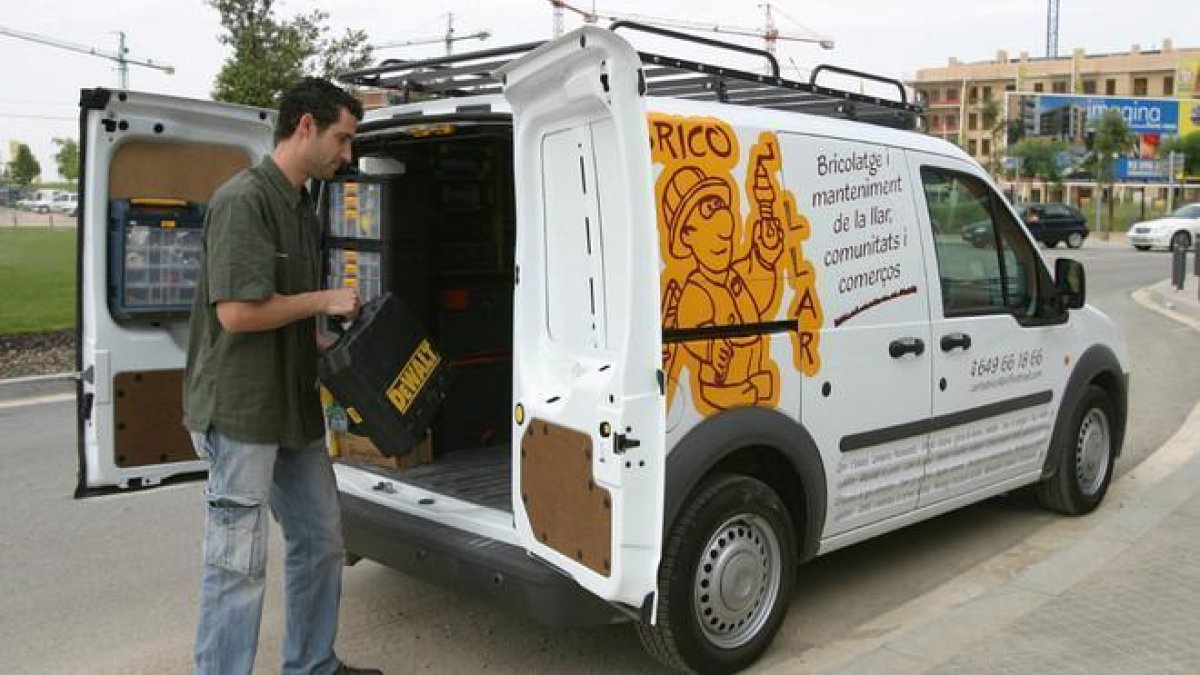 Un trabajador autónomo junto a su camioneta con material de bricolaje.-JOSEP GARCÍA (EL PERIÓDICO)