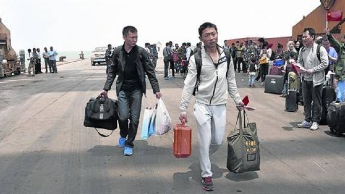 Ciudadanos chinos se preparan para embarcar en una fragata de la Armada china en Al Hudayda (Yemen).-Foto: EFE/ STR