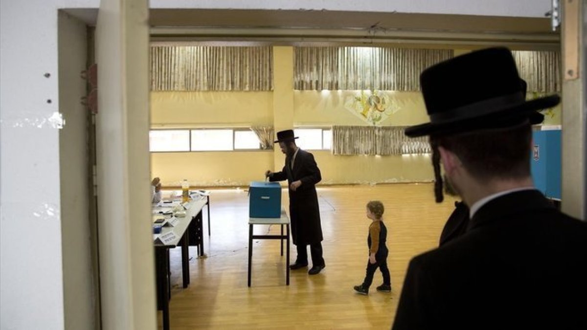 Un joven ultraortodoxo vota hoy en un colegio electoral de Bnei Brak.-AP / ODED BALITY