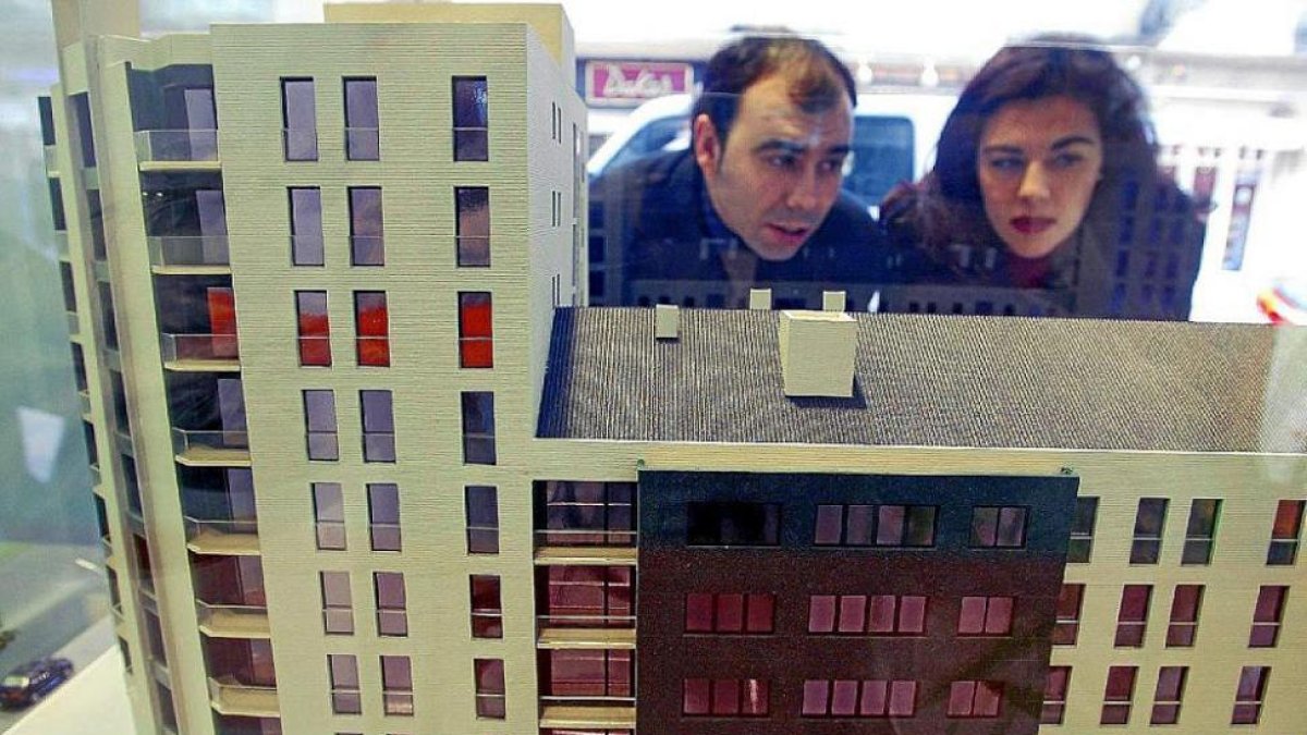 Una pareja mira la maqueta de un bloque de viviendas.-D. S.