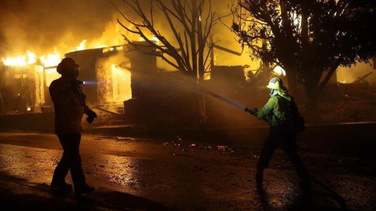 Los bomberos combaten las llamas que prenden en una vivienda en Los Ángeles, este lunes.-MARCIO JOSE SANCHEZ (AP)