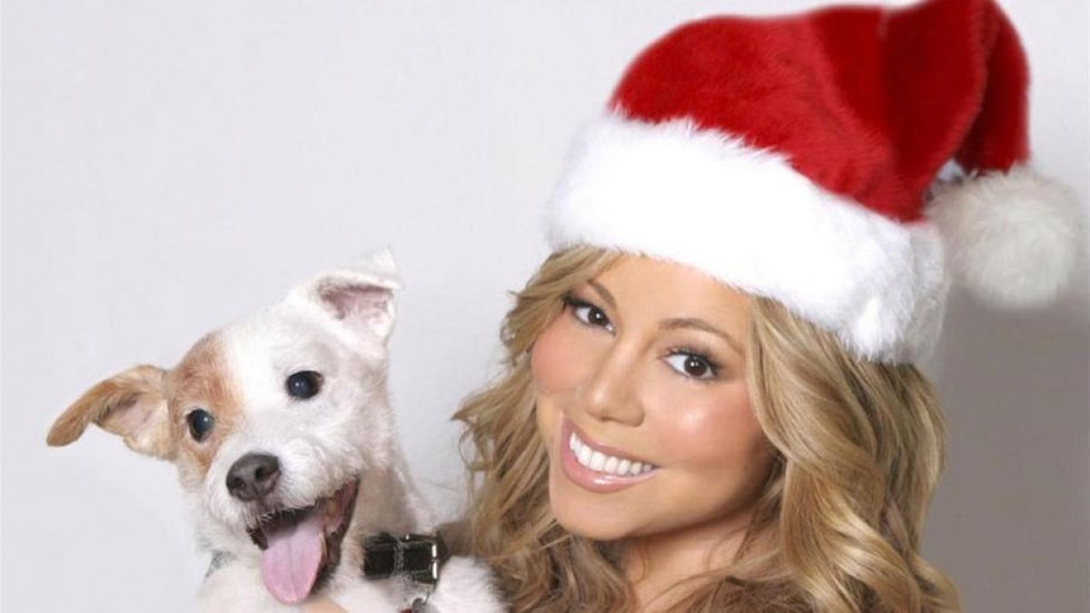 Una imagen de archivo de Mariah Carey, en una fotografía navideña, posando junto a un perro en el 2013.-MÁS PERIÓDICO