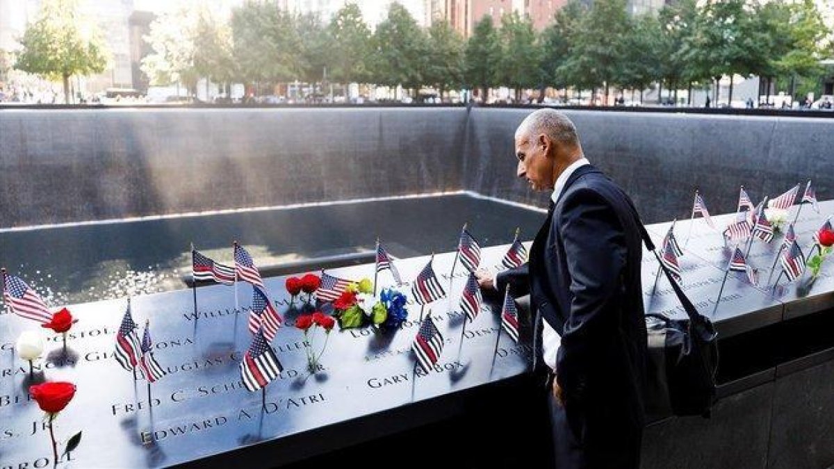 Un hombre acaricia los nombres grabados de los bomberos fallecidos en la parte sur del recordatorio a las víctimas del 11 de septiembre durante la ceremonia del 18º aniversario de la masacre.-JUSTIN LANE (EFE)
