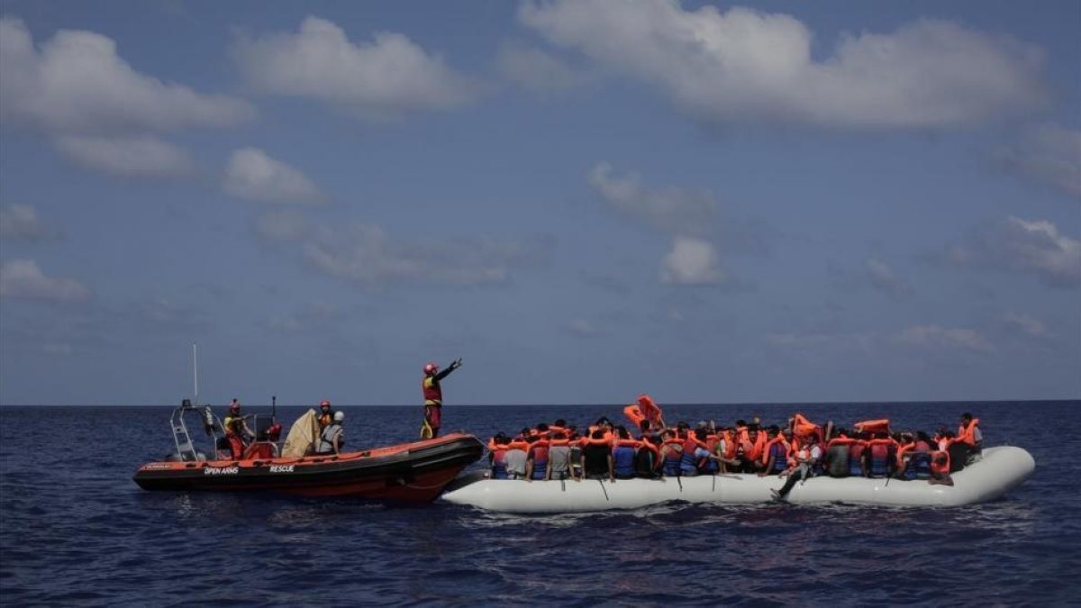 Inmigrantes esperan a ser rescatados en su atestado bote neumático por integrantes de Proactiva Open Arms, frente a las costas de Libia, el 6 de septiembre.-/ AP / BRAM JANSSEN