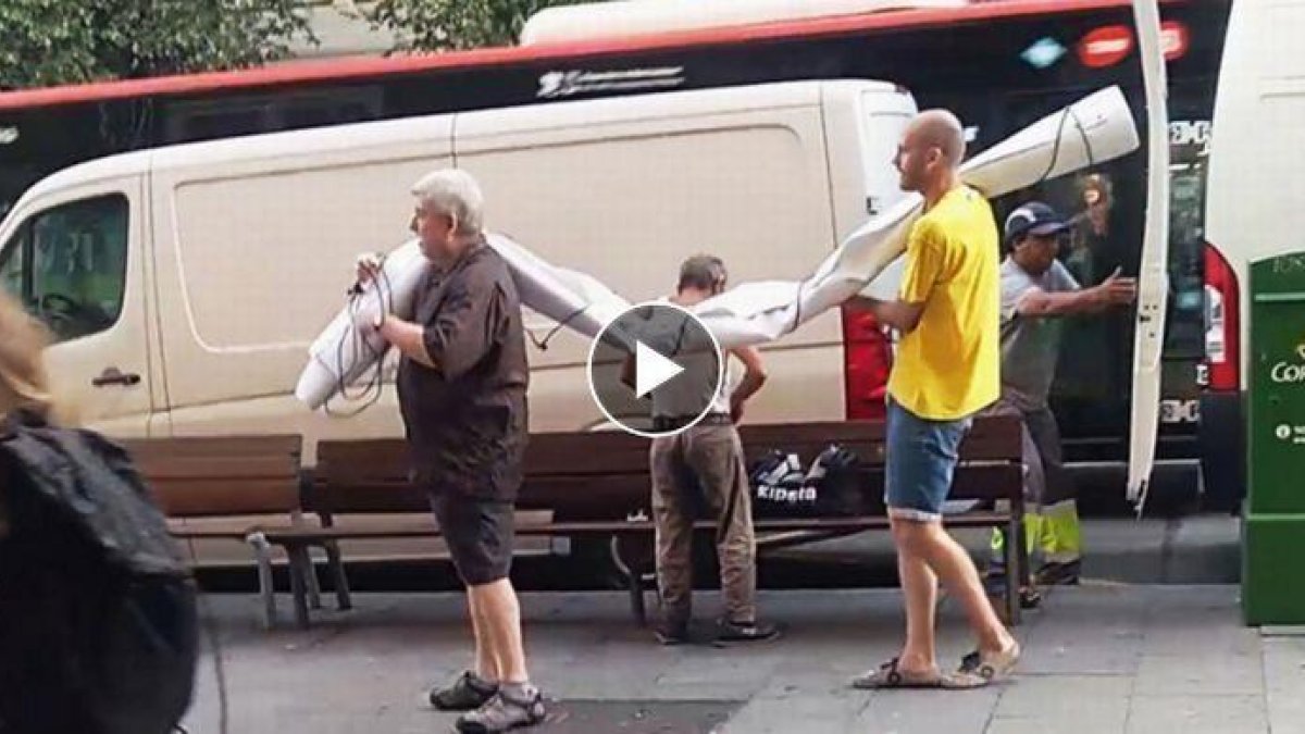 Unos hombres sacan de una furgoneta la pancarta supuestamente contraria al Rey.-VÍDEO: EL PERIÓDICO