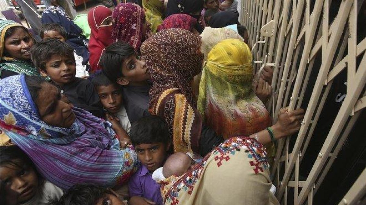 Familias paquistanís esperan en la entrada de un hospital para realizarse las pruebas de VIH.-FAREED KHAN (AP)