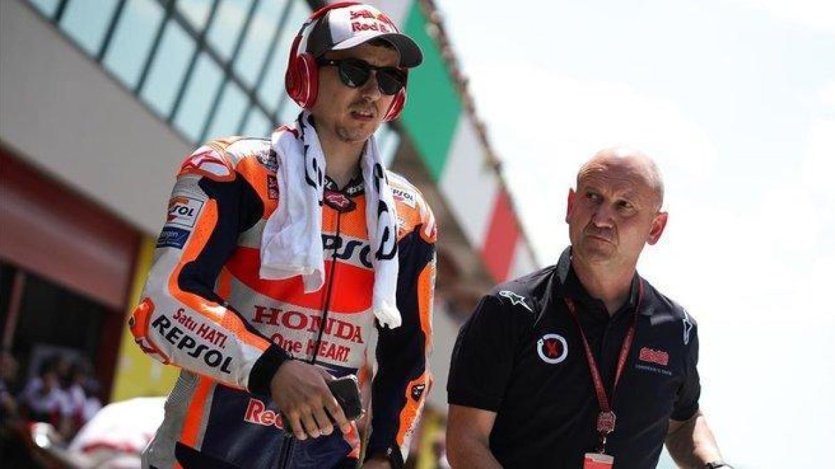Jorge Lorenzo sale de su boxe acompañado de Quique, uno de sus ayudantes.-ALEJANDRO CERESUELA