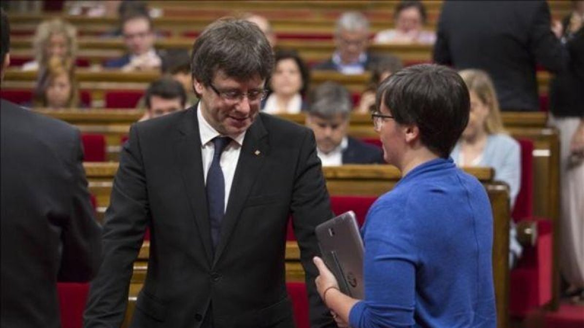 El presidente de la Generalitat, Carles Puigdemont, y la diputada de la CUP Mireia Boya, en el Parlament.-ALBERT BERTRAN