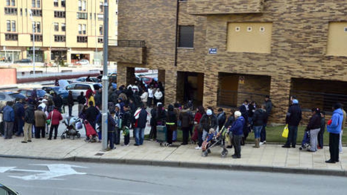 Decenas de personas ayer, en la avenida Duques de Soria para recoger alimentos que entrega Cruz Roja. / VALENTÍN GUISANDE-