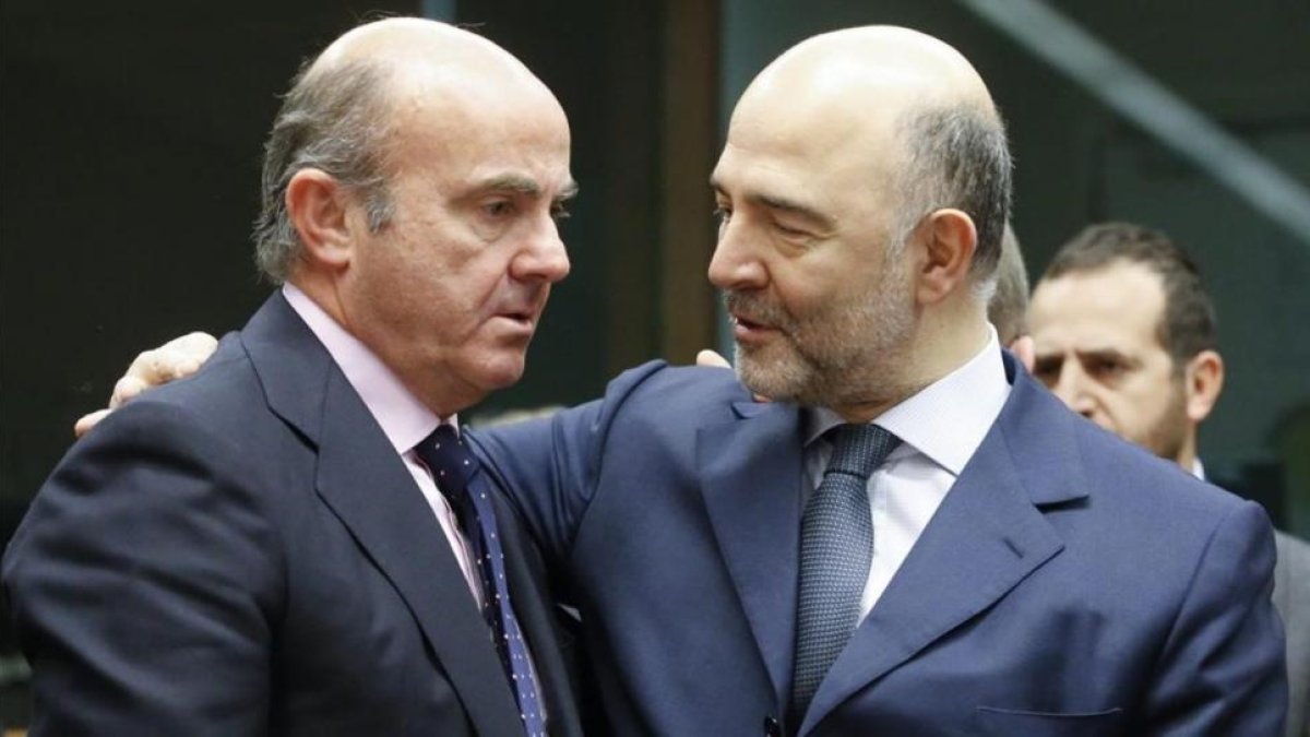 El ministro español de Economía, Luis de Guindos, conversa con el comisario europeo de Asuntos Economicos, Pierre Moscovici.-EFE