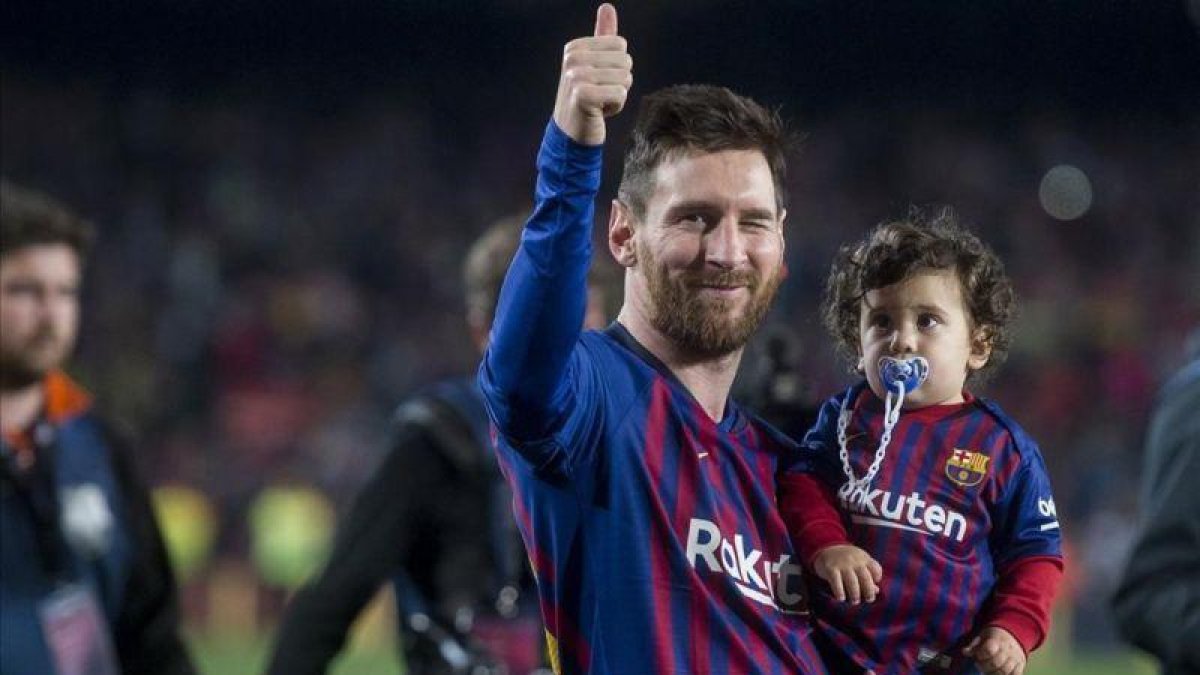 Messi da la vuelta al campo con Ciro, su tercer hijo, en brazos, en la fiesta del alirón tras el triunfo sobre el Levante.-JORDI COTRINA