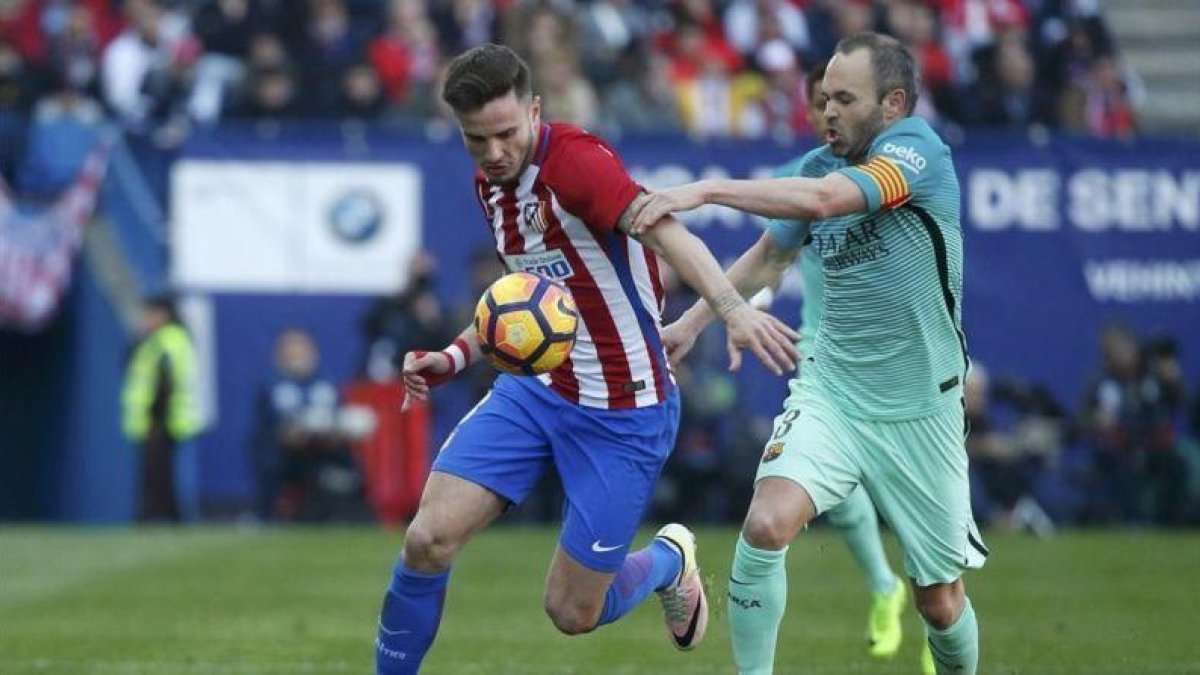 Iniesta pelea por el balón con Saúl, el jugador del Atlético, en el Calderón.-REUTERS / JUAN MEDINA