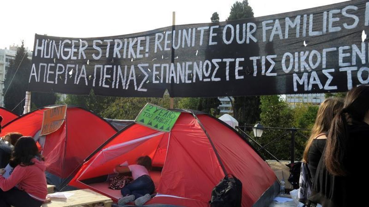 Grupo de refugiados que iniciaron esta semana una huelga de hambre ante el Parlamento griego, en la céntrica plaza de Syntagma, para reclamar la reunificación con sus familias en Alemania.-EFE