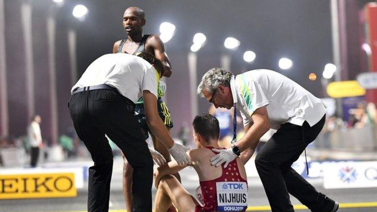 Un participante del maratón necesita ayuda a la conclusión de la prueba en el Mundial de Doha.-EFE / EPA / NOUSHAD THEKKAYIL
