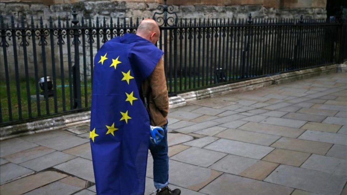 Un hombre con la bandera de la UE camina por una calle de Londres tras participar en una protesta en contra del 'brexit'.-AFP / JUSTIN TALLIS