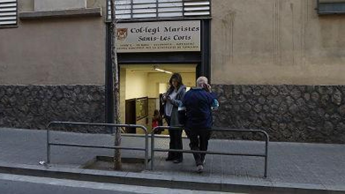 Un hombre borra a las ocho de la mañana las pintadas aparecidas en el colegio de los Maristas de Sants-Les Corts.-JULIO CARBÓ