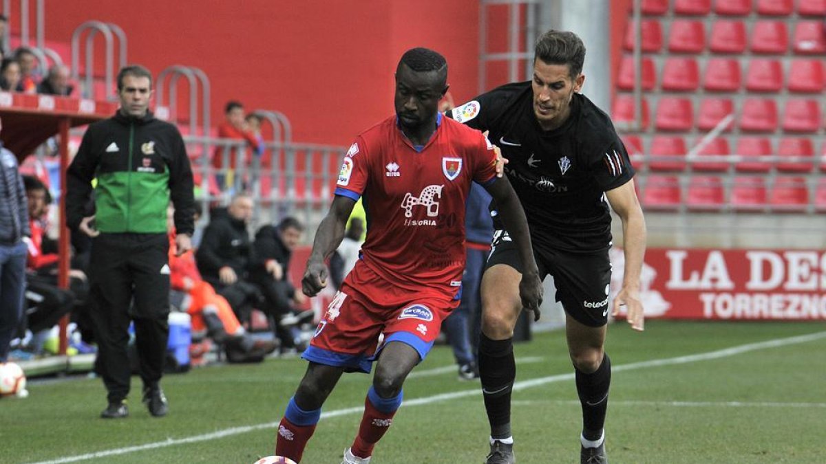 Diamanka conduce el balón ante Álex Alegría durante el partido del Numancia frente al Sporting.-VALENTÍN GUISANDE