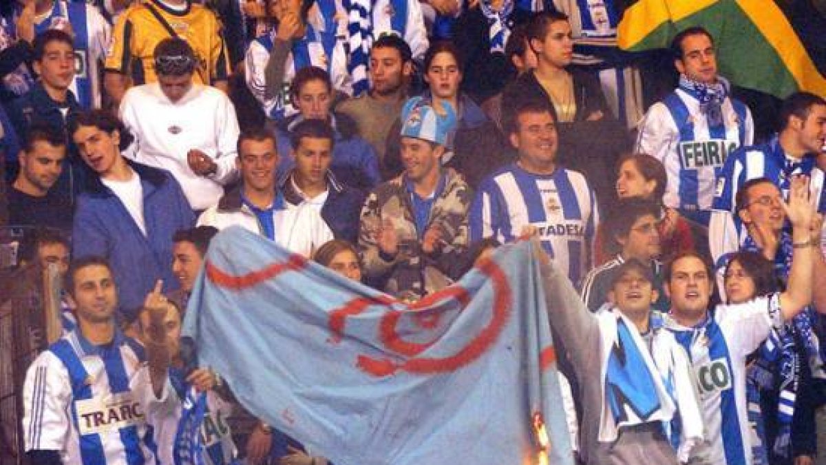 Aficionados del grupo radical Riazor Blues queman una bandera durante un partido, en octubre del 2003.-Foto: ARCHIVO / EFE