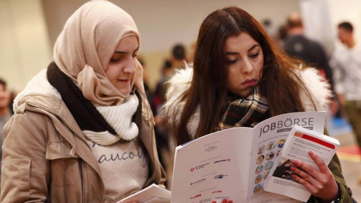 Dos mujeres visitan la segunda feria del trabajo para los inmigrantes y los refugiados celebrada en Berlín en el 2015.-REUTERS / FABRIZIO BENSCH
