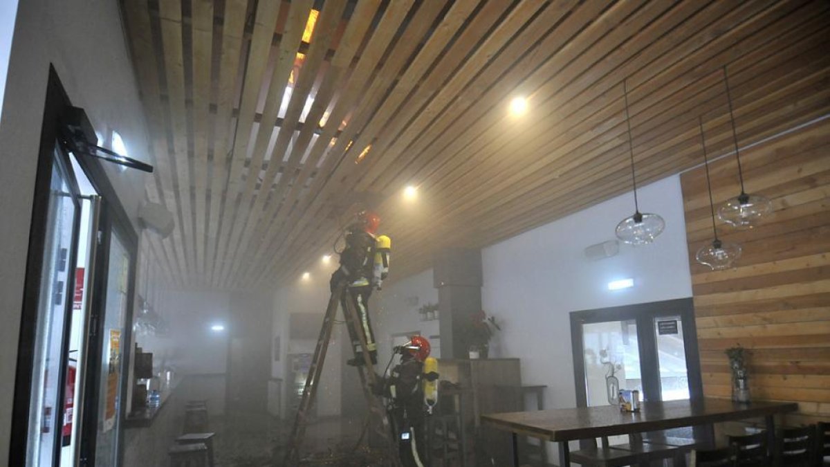 Dos bomberos en las labores de extinción del incendio declarado en el restaurante de Soto Playa.-VALENTIN GUISANDE