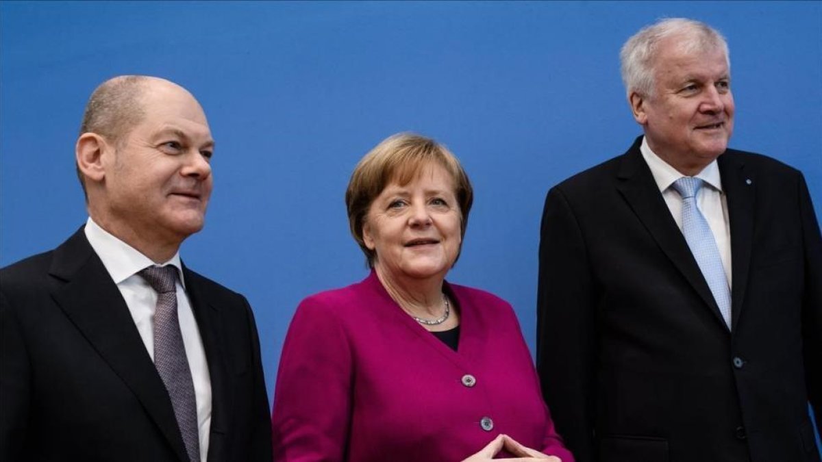 De derecha a izquierda,  el líder del Partido Socialdemocrata, Horst Seehofer, la cancillera alemana, Angela Merkel y el líder de la Unión Socialcristiana, Olaf Zcholz.-/ EFE / CLEMENS BILAN