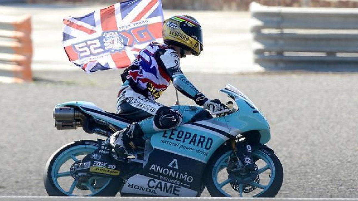 Danny Kent pasea la bandera británica por el circuito de Cheste tras convertirse en campeón de Moto3.-AFP / JOSÉ JORDÁN