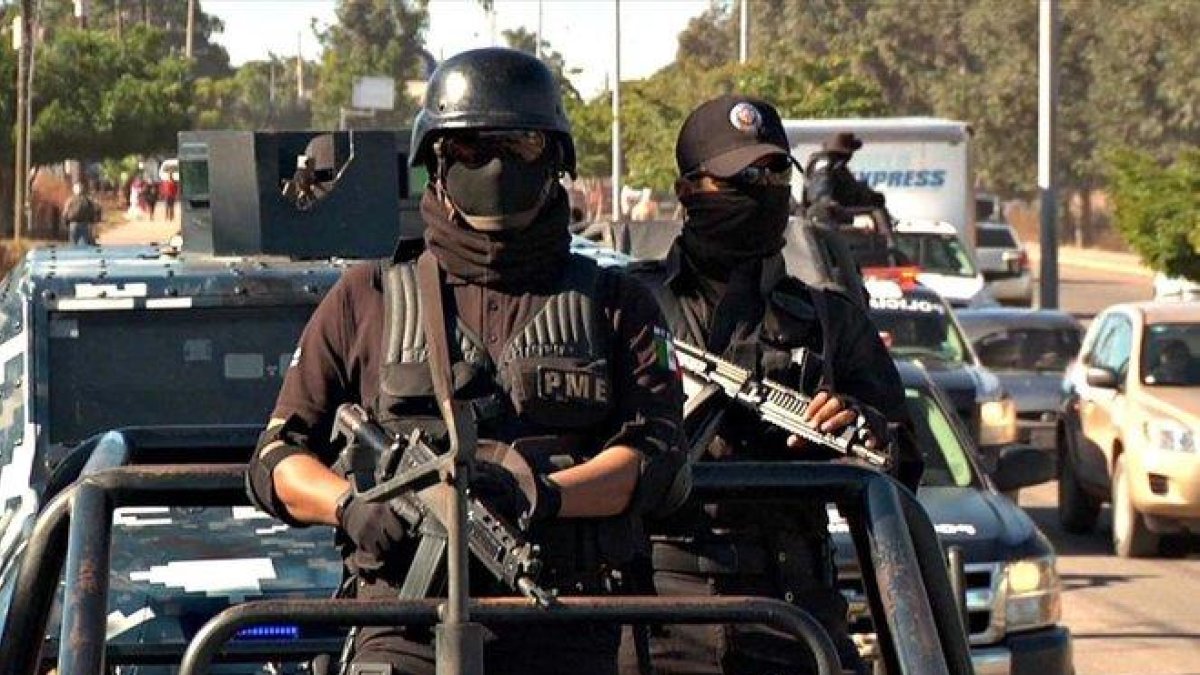 Dos agentes de la policía mexicana en un convoy de seguridad.-EL PERIÓDICO
