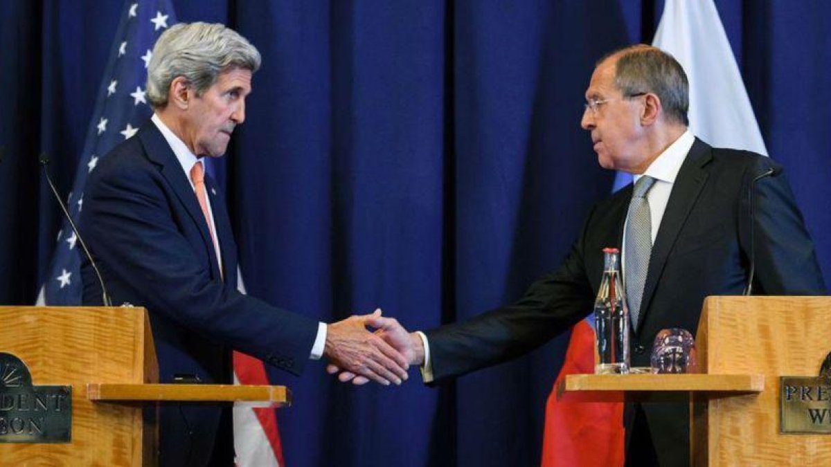 El secretario de Estado, John Kerry, le da la mano al ministro ruso de Exteriores, Serguei Lavrov.-FABRICE COFFRINI / AFP