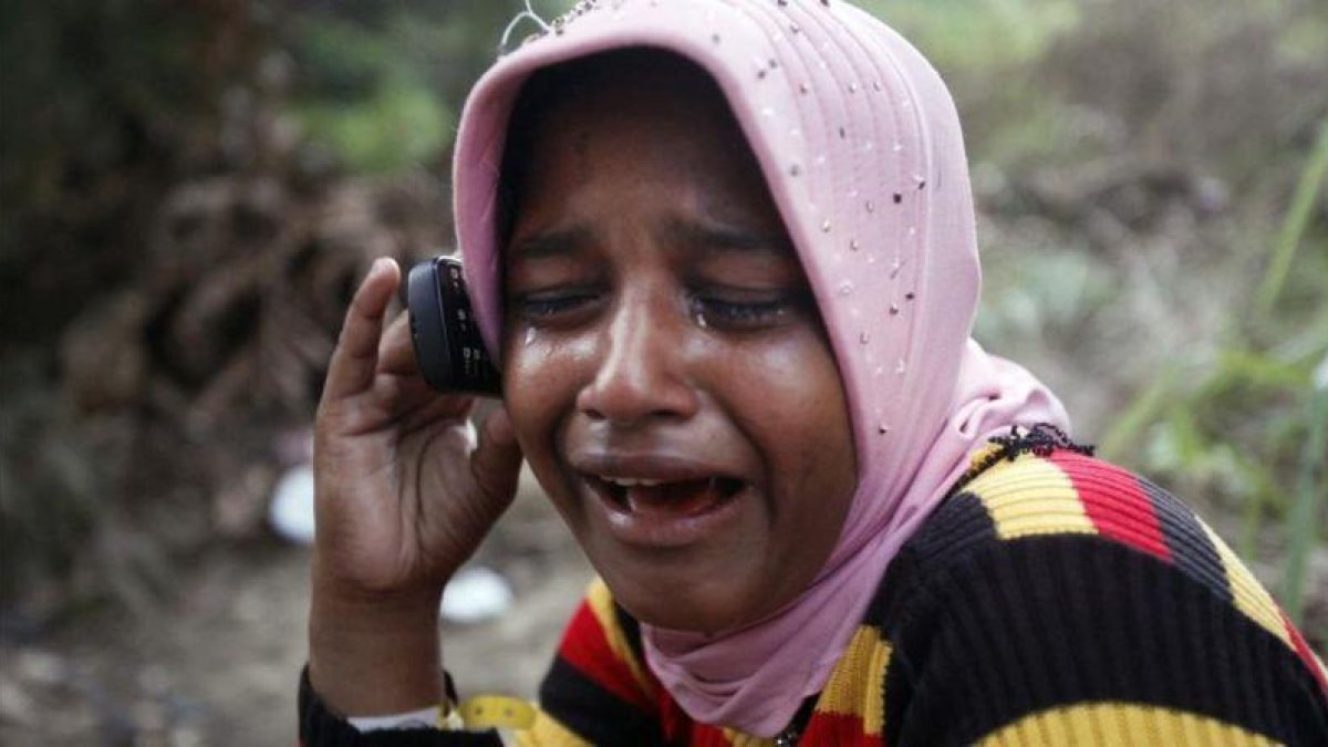 Una refugiada rohingya llora mientras habla por teléfono con su hermano.-BINSAR BAKKARA