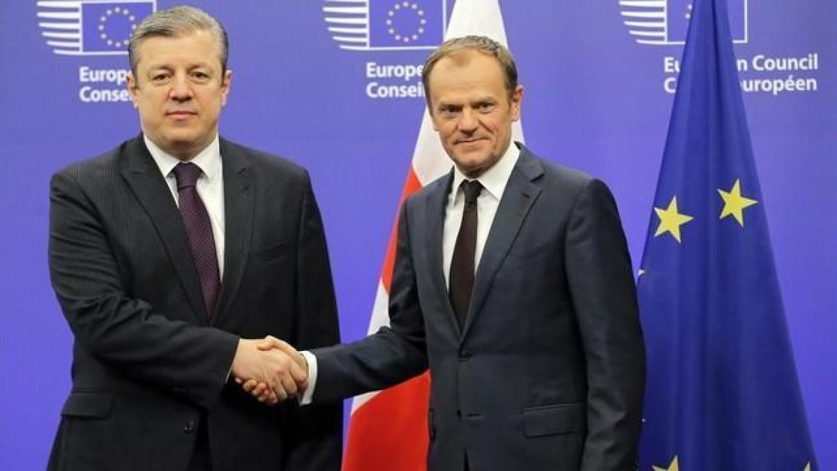 Tusk (derecha) estrecha la mano del primer ministro de Georgia, antes de su reunión en la sede del Consejo Europeo en Bruselas, el 9 de febrero.-EFE / OLIVIER HOSLET