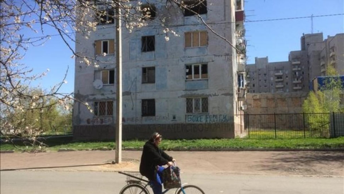 Una mujer pasa frente a un edificio afectado por los bombardeos en Avdiivka.-MARC MARGINEDAS