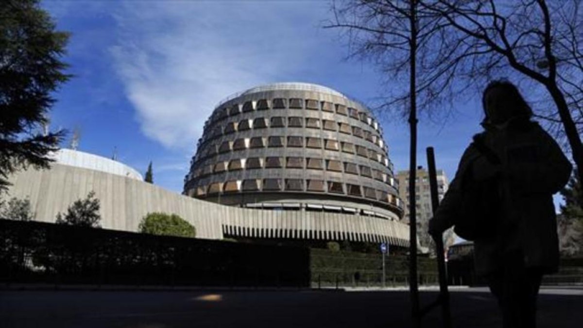 Una transeúnte pasa junto a la sede del Tribunal Constitucional, en Madrid.-AGUSTÍN CATALÁN