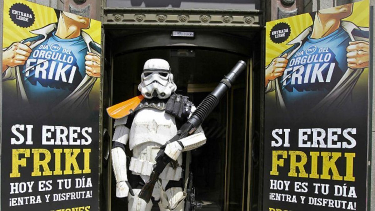 Un Storm Trooper (soldado de la fuerza oscura de 'Star Wars') frente a un cartel para 'reclutar' frikis.-