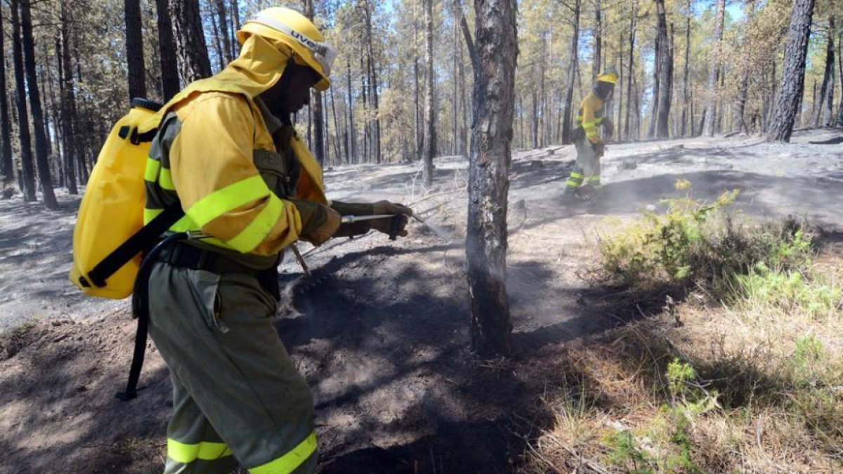 Las cuadrillas de la Junta refrescan la parte alta del terreno incendiado a mediodía de ayer.-ÁLVARO MARTÍNEZ