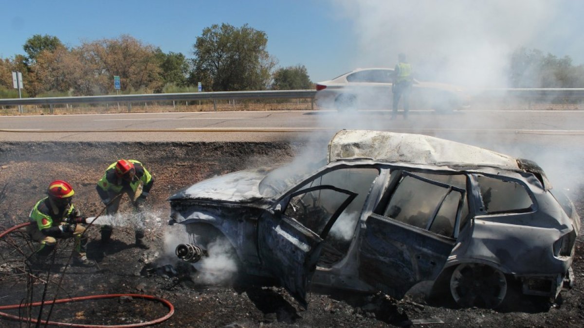 Los bomberos sofocan las llamas con el vehículo completamente calcinado. VICENTE-ICAL