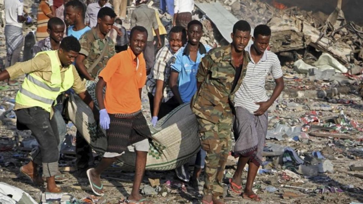 Traslado de un cadáver del lugar donde se ha producido uno de los atentados con bomba en Mogadiscio.-FARAH ABDI WARSAMEH / AP