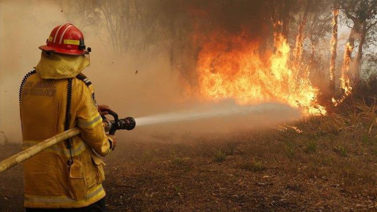 Un bombero trabaja en la extinción de un incendio forestal en los alrededores de Sídney, en Australia-DPA
