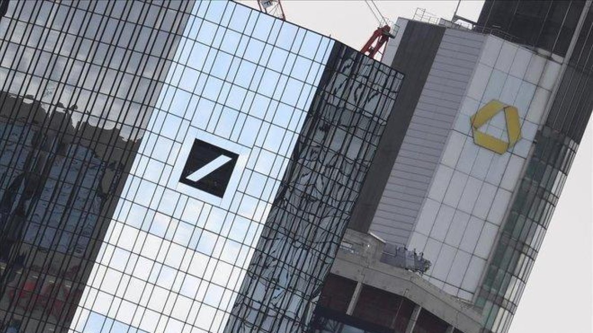 Logotipos del Deutsche Bank y el Commerzbank en sus respetivas desde de Fráncfort.-ARNE DEDERT (AP)
