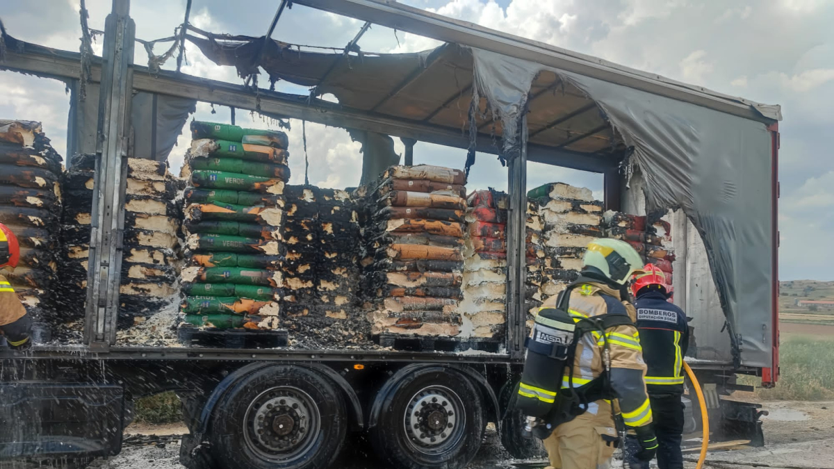 Los bomberos trabajan en el remolque incendiado.